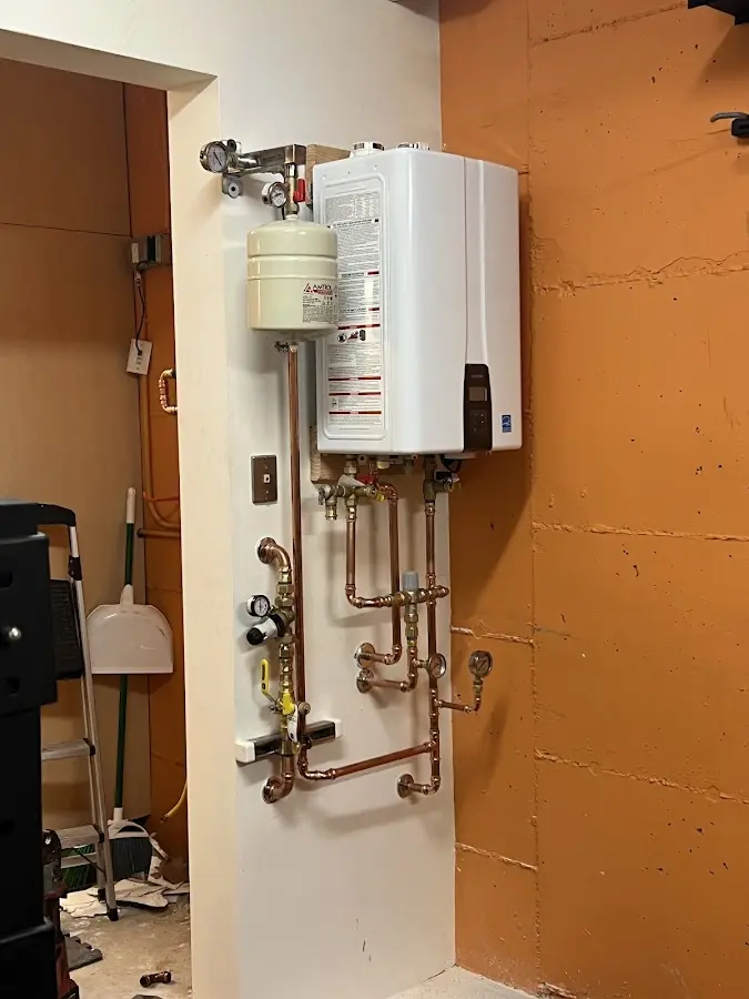 Plumbing technician inspecting water heater connections in Addis
